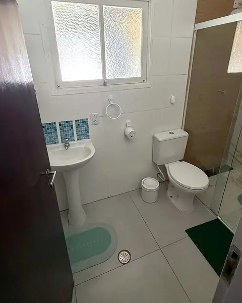 Banheiro com pia, vaso sanitário e box de vidro