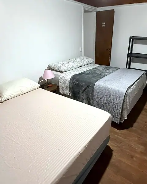 Quarto claro com cama de casal e cama de solteiro